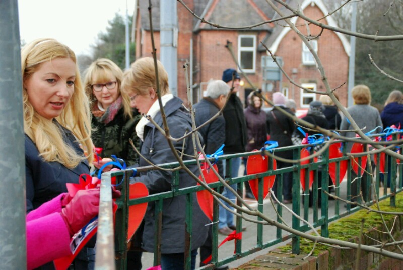 Protesters tie hearts to the school railings